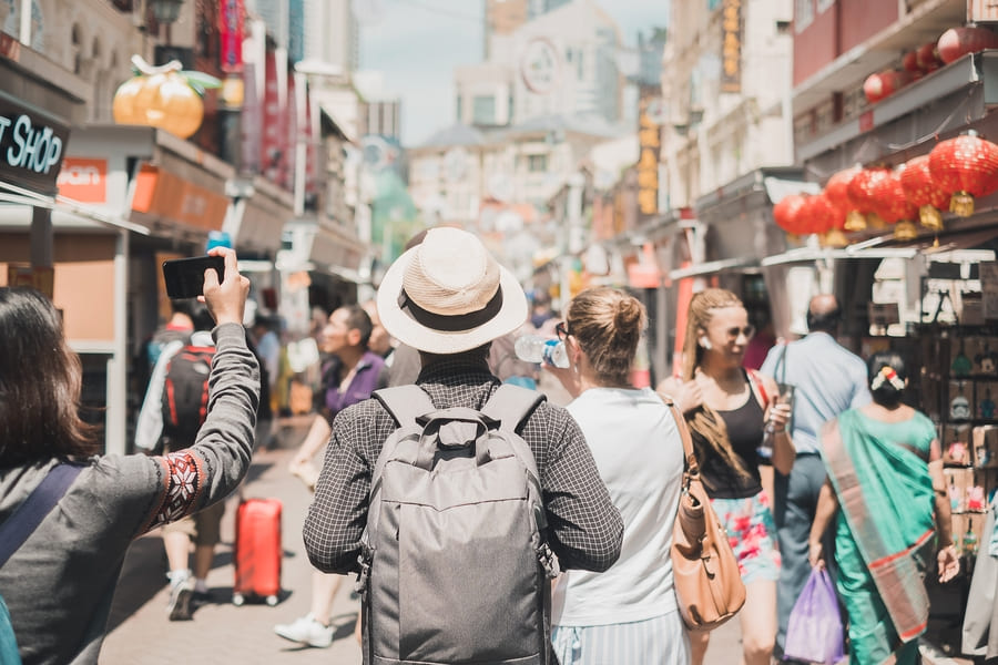Viajero hombre con mochila entre mucha gente calle china